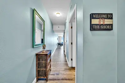 a hallway with a welcome to the store sign on the wall at Shores of Panama 1802 in Panama City Beach