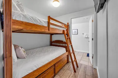 a bedroom with two bunk beds and a doorway at Shores of Panama 1802 in Panama City Beach